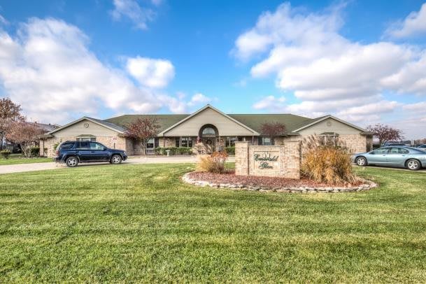 A suburban house with a well-maintained lawn under a partly cloudy sky.