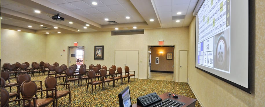 An empty conference room with arranged chairs and a carpeted floor.