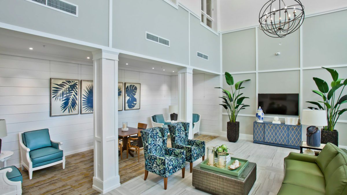 A modern living room with stylish furniture, high ceilings, and ample natural light.