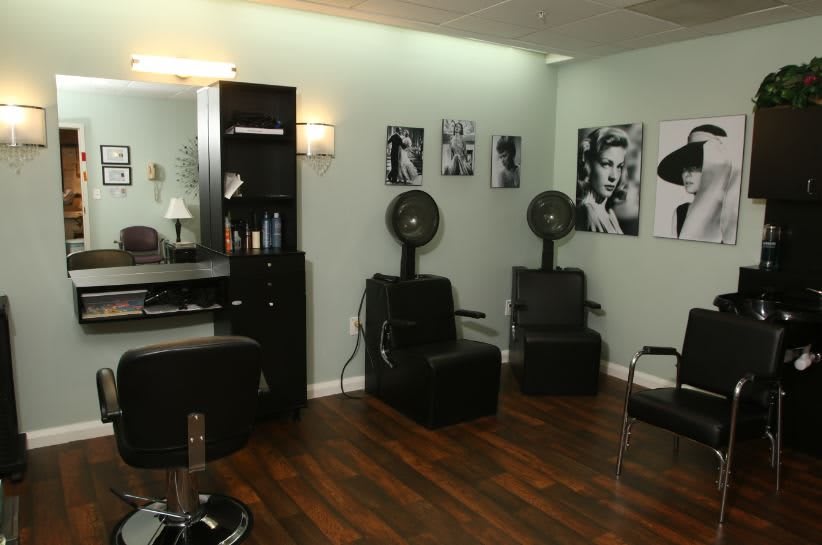A modern salon interior with styling chairs, hair dryers, and wall art.