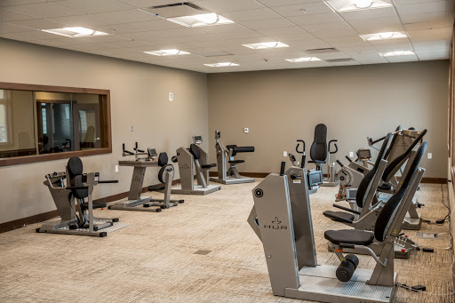 An interior view of a modern gym featuring various exercise machines.