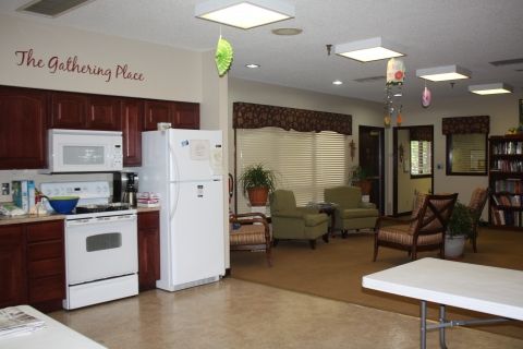 A cozy living space featuring a kitchen with appliances and a seating area.