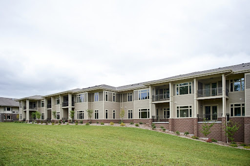 A view of a modern apartment building set against a cloudy sky.