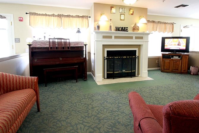 A cozy living room featuring a fireplace and a piano.