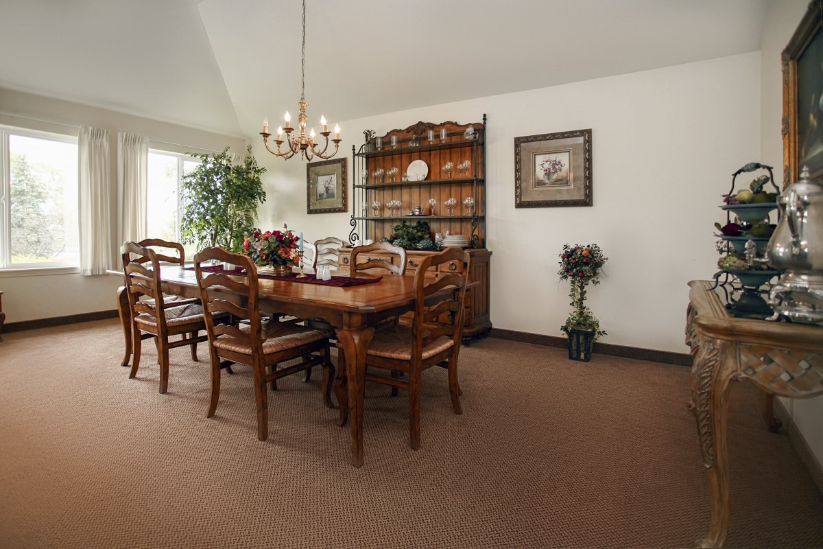 A classic dining room with a wooden table set and chandelier.
