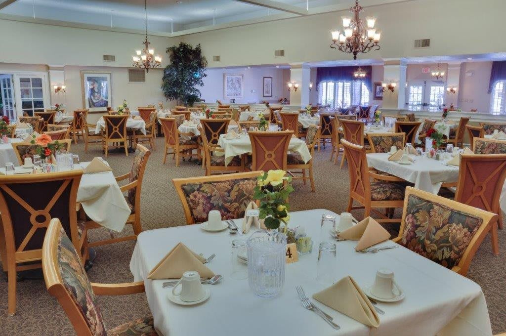 An elegantly decorated dining room with neatly arranged tables and chairs, ready for guests.