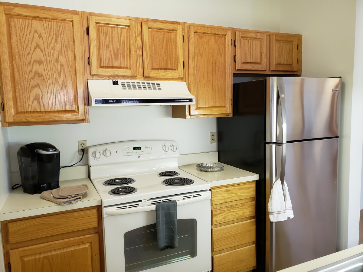A modern kitchen with a stove, oven, and stainless steel refrigerator.