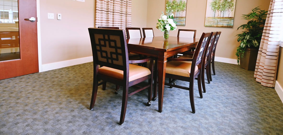 A beautifully set dining room with a wooden table and chairs.