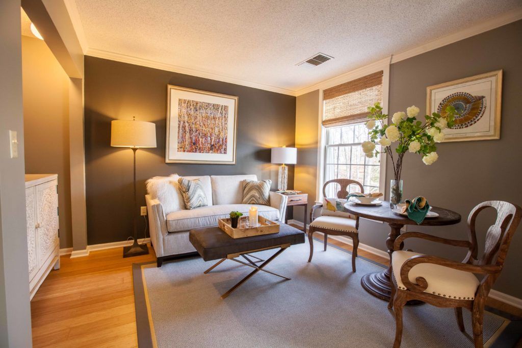 A cozy living room with elegant decor, featuring a sofa, coffee table, and artwork.