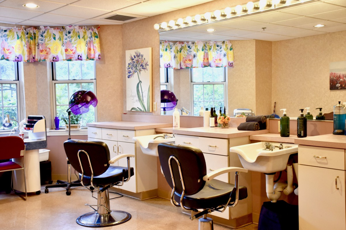 A well-lit hair salon interior with styling stations and chairs.