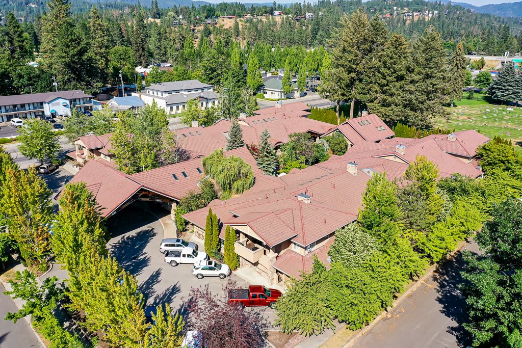 Aerial view of a large residential property surrounded by trees and greenery in a suburban area.