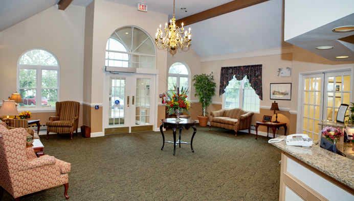 A spacious and elegantly decorated lobby with a chandelier, seating area, and large windows.