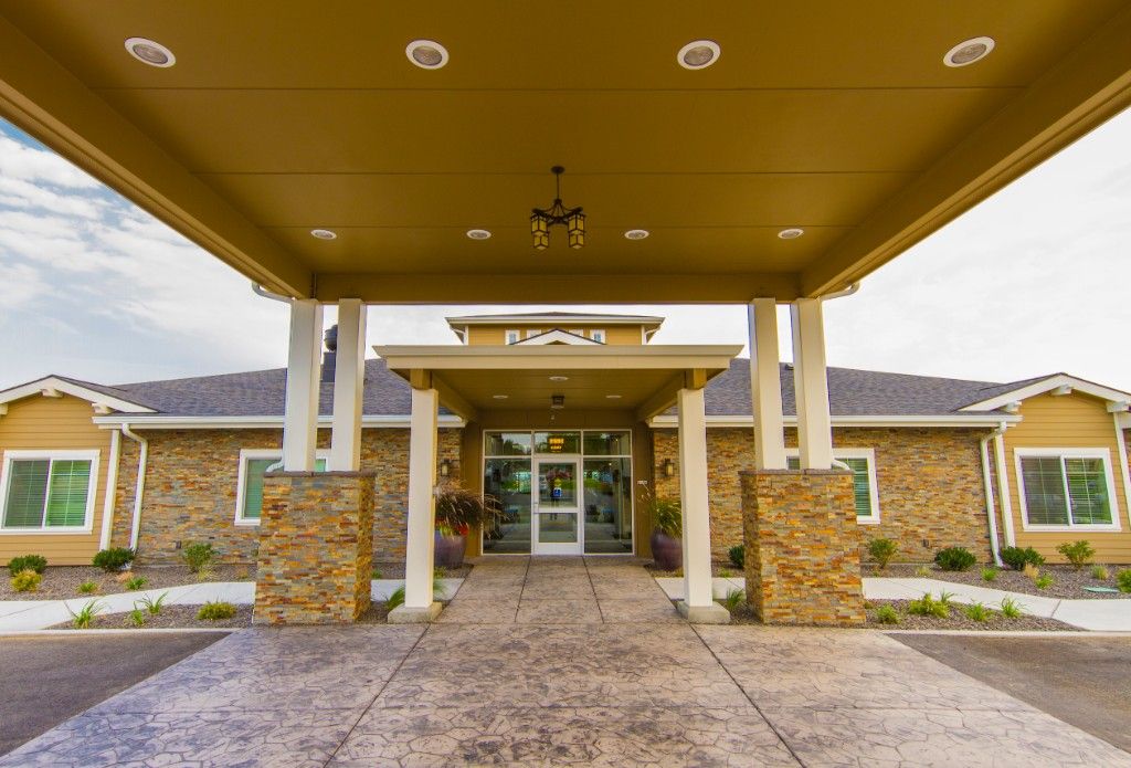 Front entrance of a modern building with stone columns and an awning.
