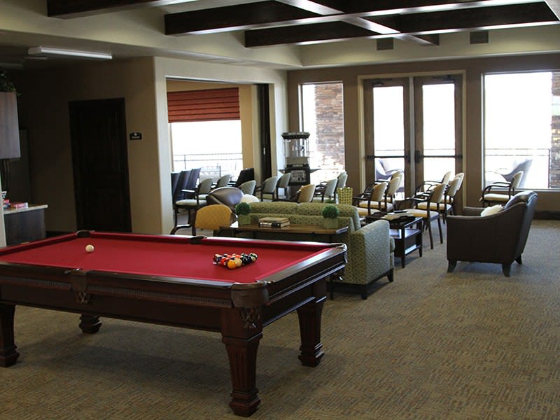 A cozy game room featuring a pool table and comfortable seating.