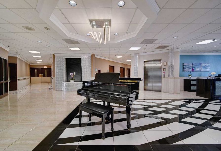 A luxurious lobby featuring a grand piano and elegant chandelier.