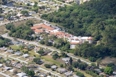 An aerial view of a residential area with buildings surrounded by trees.