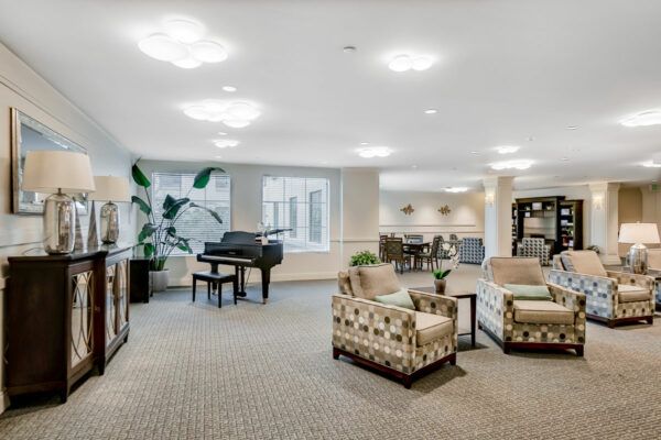A spacious living area featuring a piano and comfortable seating.