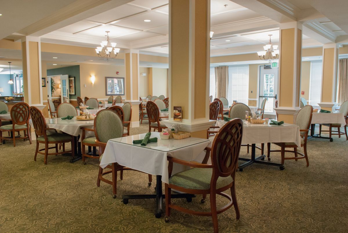 An elegant dining area with neatly arranged tables and chairs, featuring soft lighting and tasteful decor.