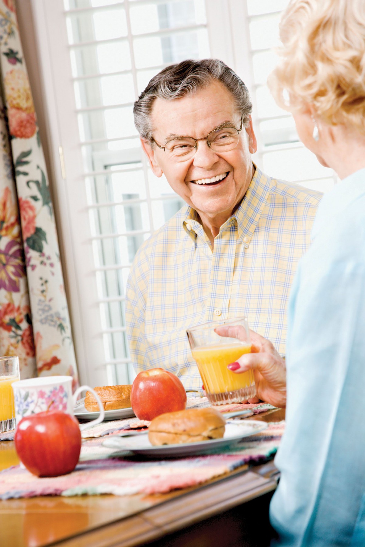 An elderly couple enjoying a breakfast together at home.