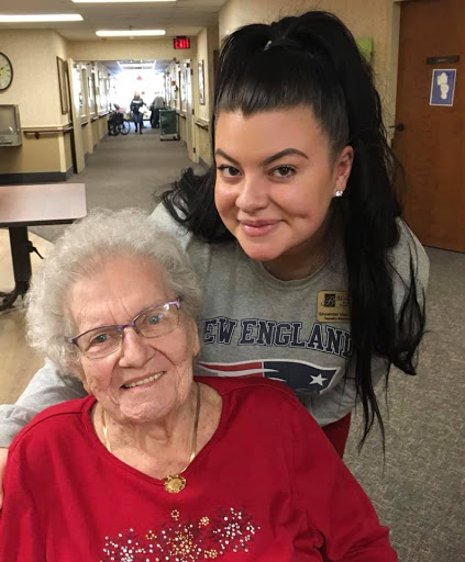 A joyful moment shared between a young woman and an elderly lady in a cozy indoor setting.