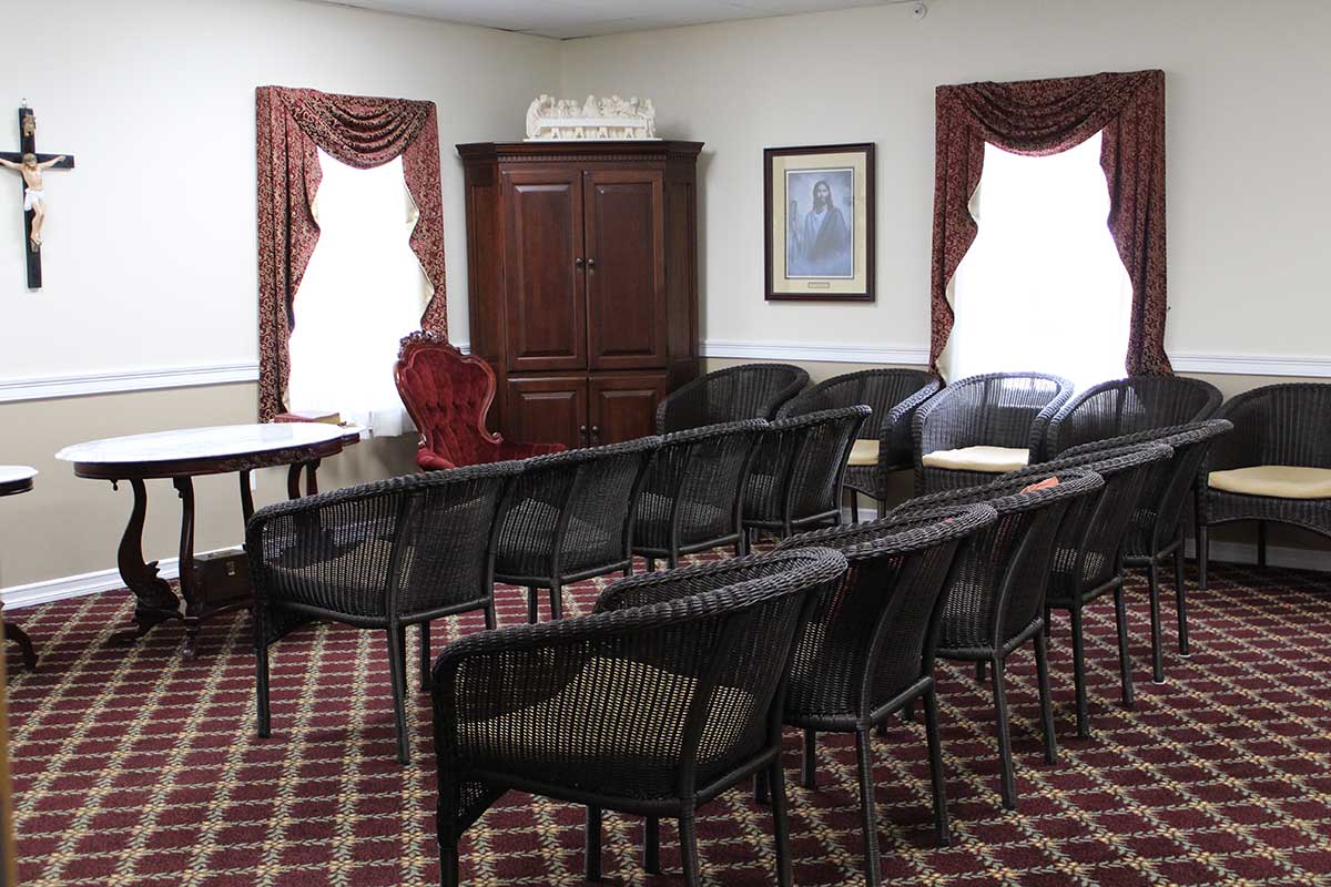 A small meeting room with arranged chairs and carpeted flooring.