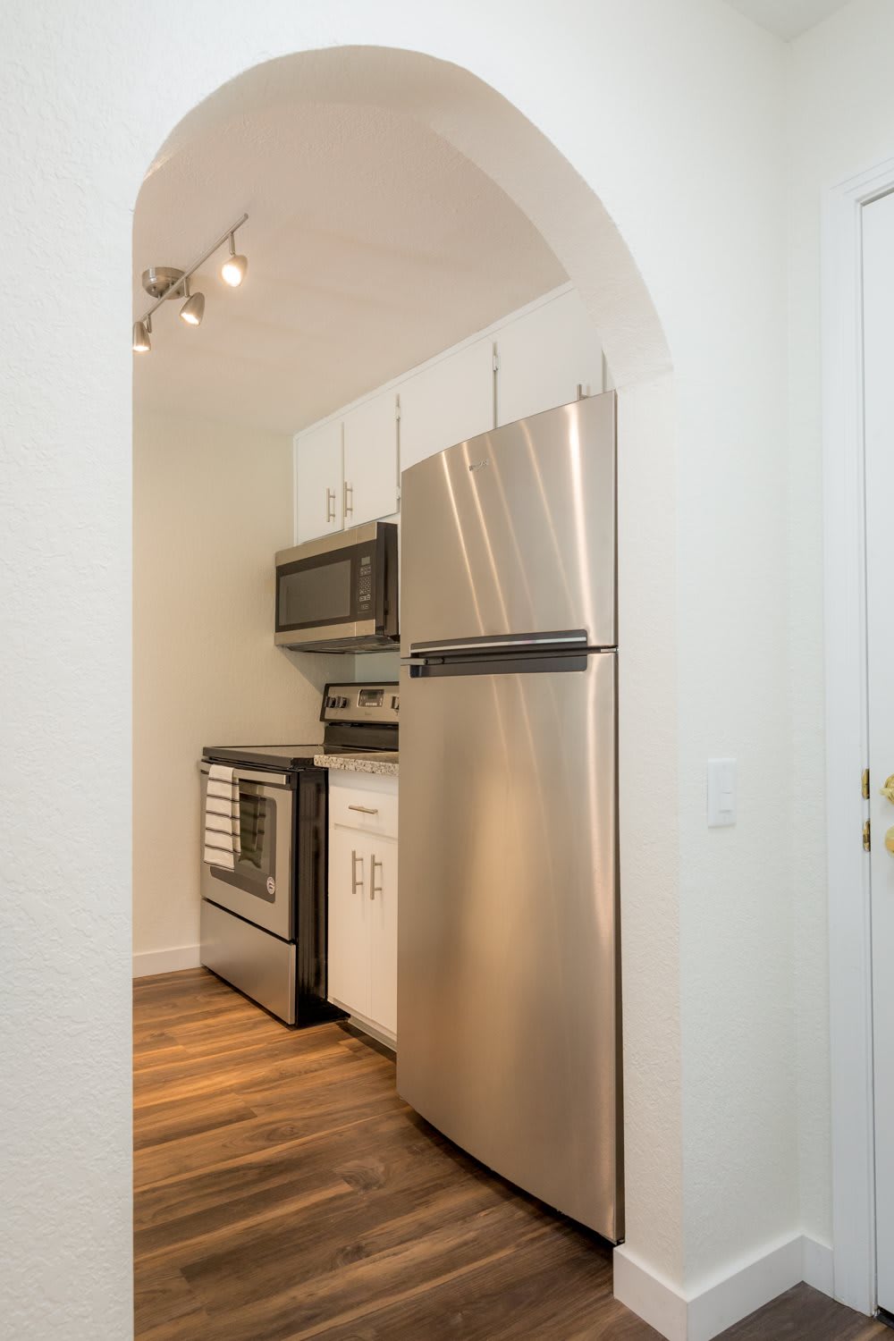 A compact modern kitchen with stainless steel appliances and white cabinetry.