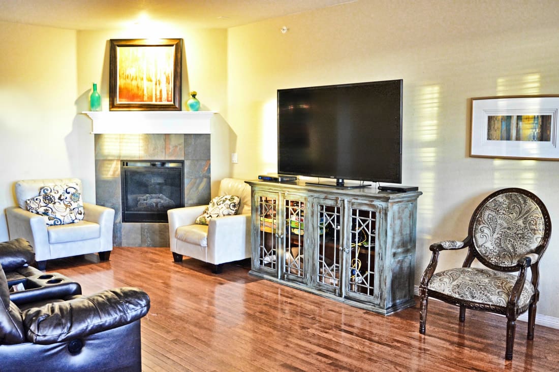 A cozy living room with a TV, fireplace, and comfortable seating.