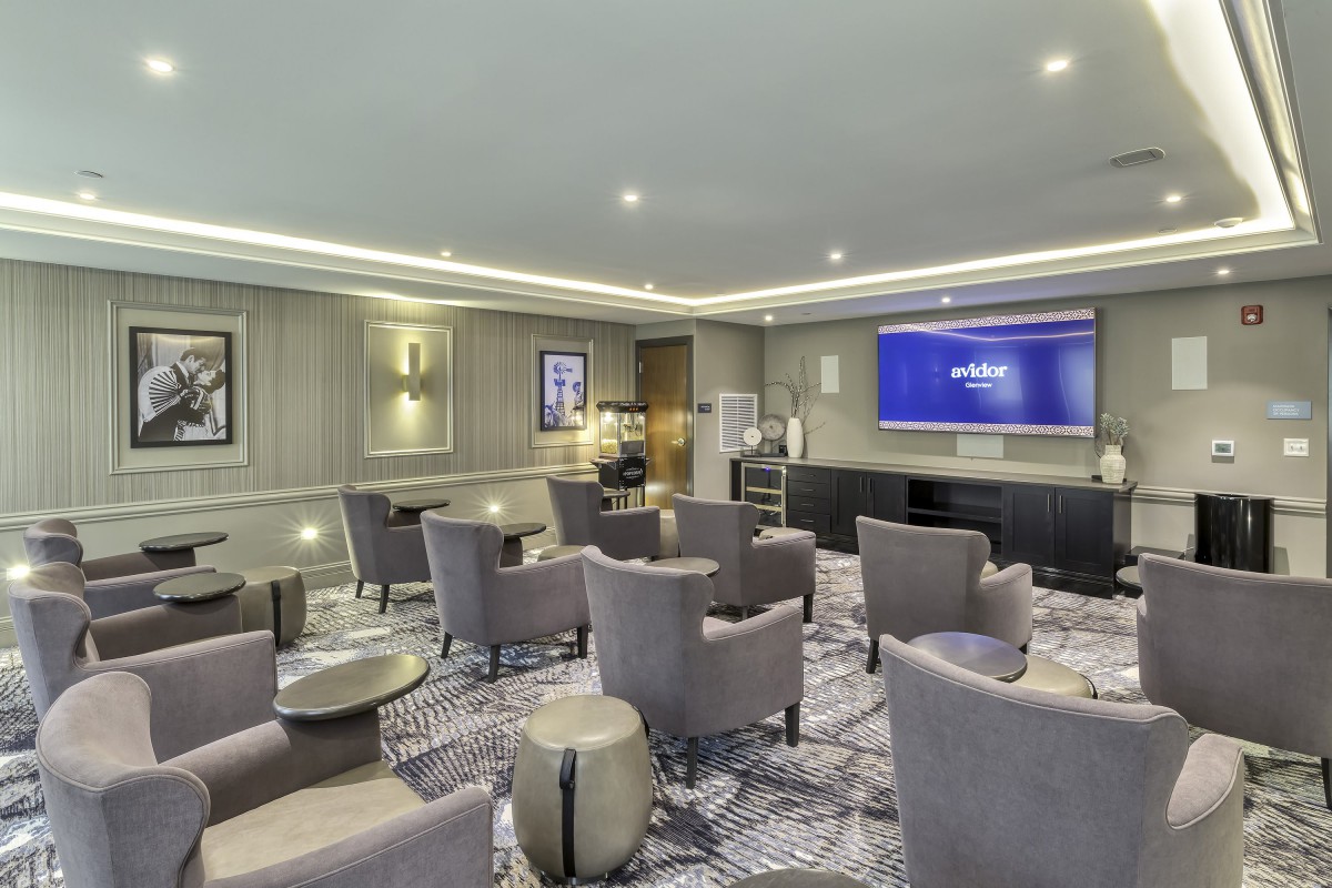 A modern conference room with comfortable seating and a large screen.