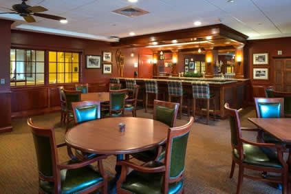 A cozy bar and dining area with wooden furniture and ambient lighting.