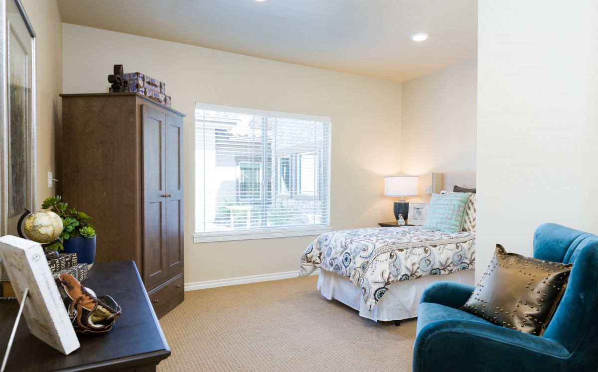 A cozy bedroom with a large bed, wardrobe, and a window providing natural light.