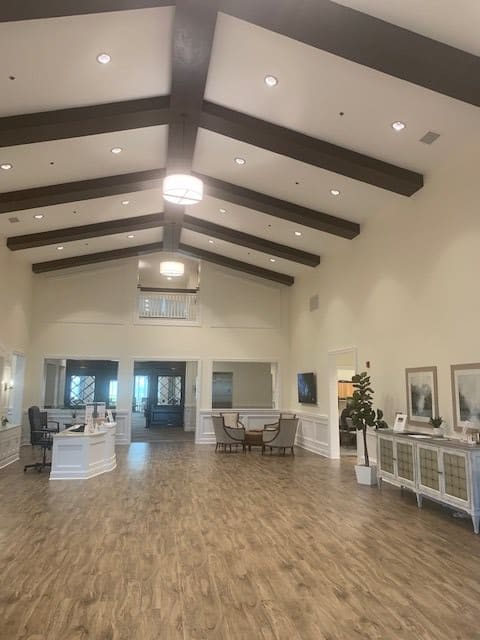 A spacious, elegantly designed lobby area featuring wooden ceiling beams and comfortable seating.