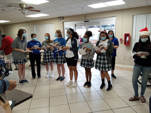 Students participating in a group activity while wearing masks inside a school setting.