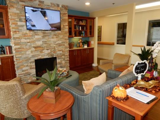 A cozy living room with a stone fireplace, television, and comfortable seating.