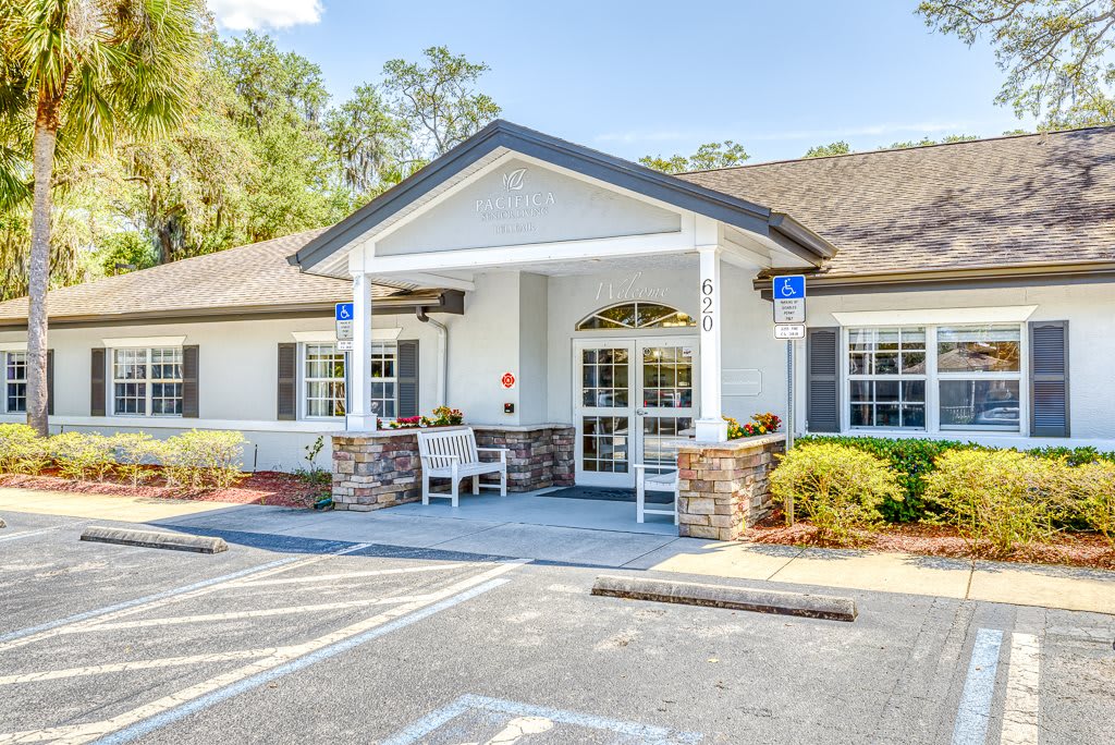 A building entrance with a covered porch and adjacent parking spaces.