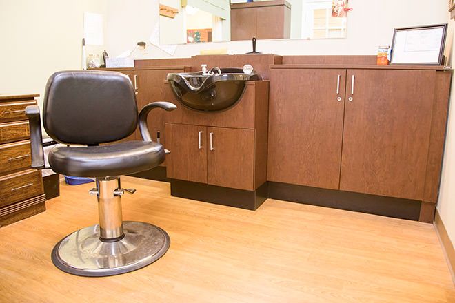 A modern hair salon setup with a styling chair and washbasin.
