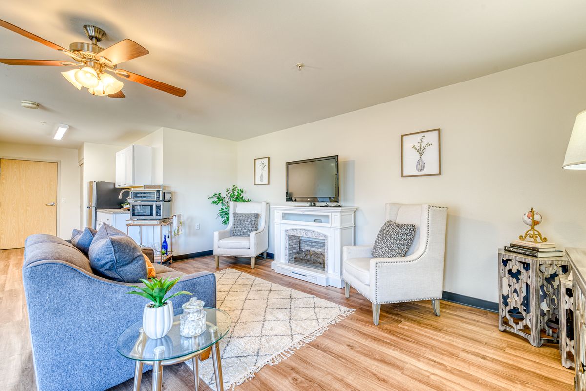 A bright and well-decorated living room featuring comfortable seating, a television, and stylish decor.