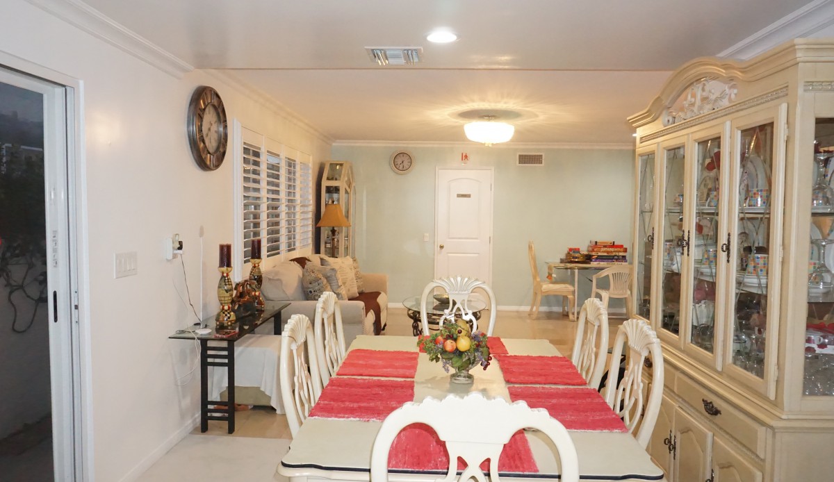A cozy dining area with a table set for a meal, adjacent to a comfortable living space.