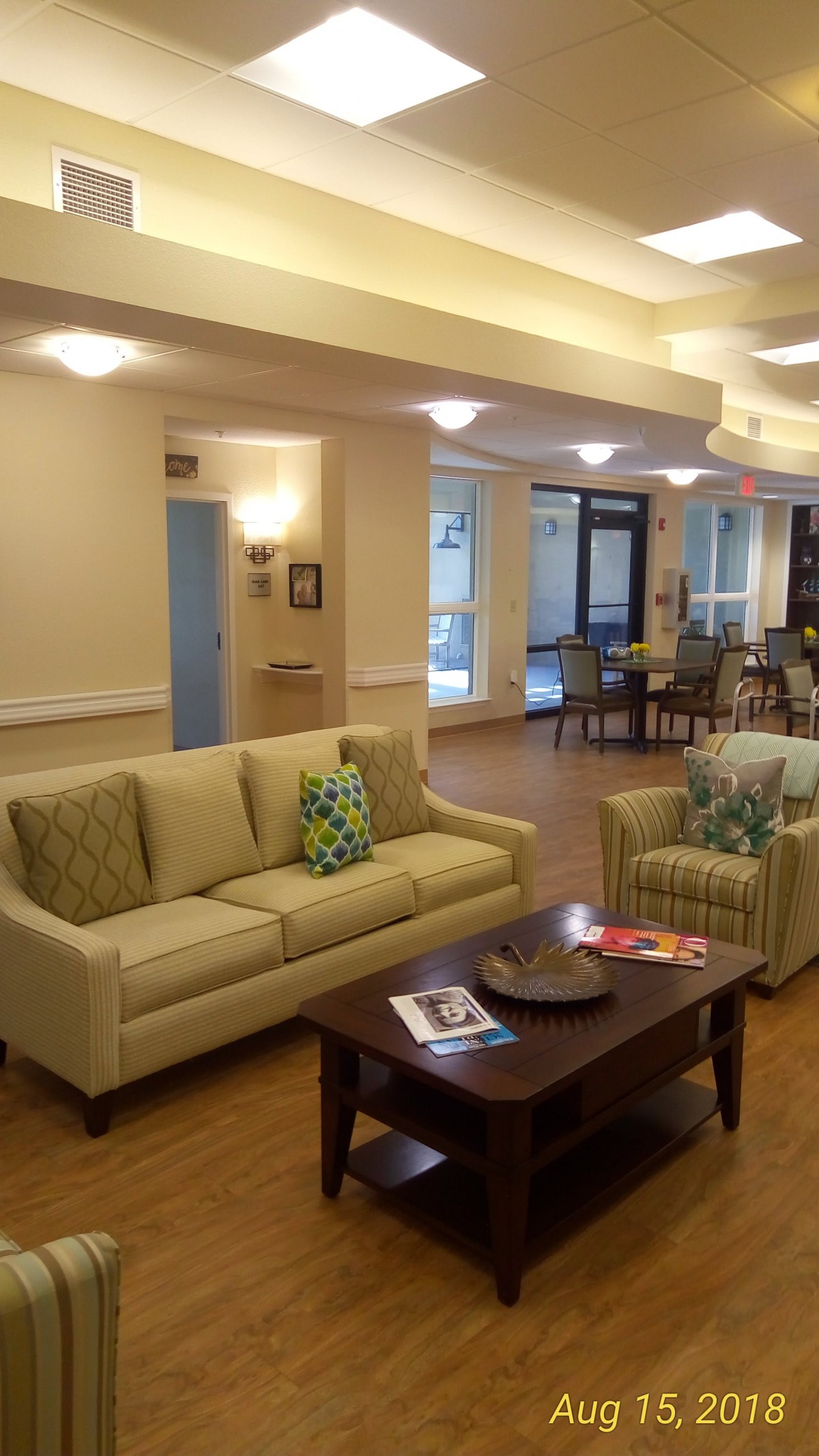 A cozy living room with a comfortable sofa and coffee table, featuring decorative cushions and soft lighting.