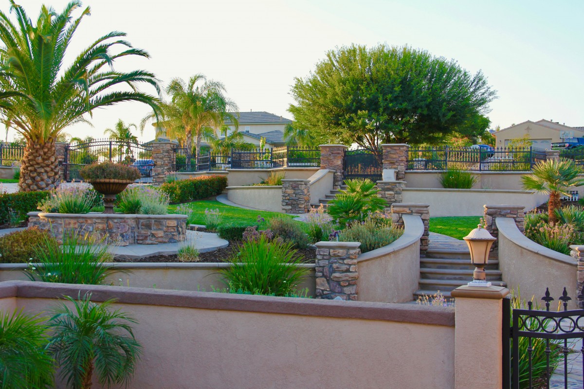 A beautifully landscaped garden with terraced stone walls and lush greenery.