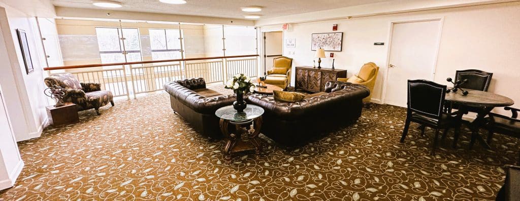 A cozy lobby seating area with a sofa, chairs, and decorative elements.