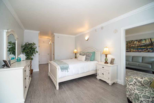 A bright and cozy bedroom featuring a white bed frame, soft bedding, and stylish decor.