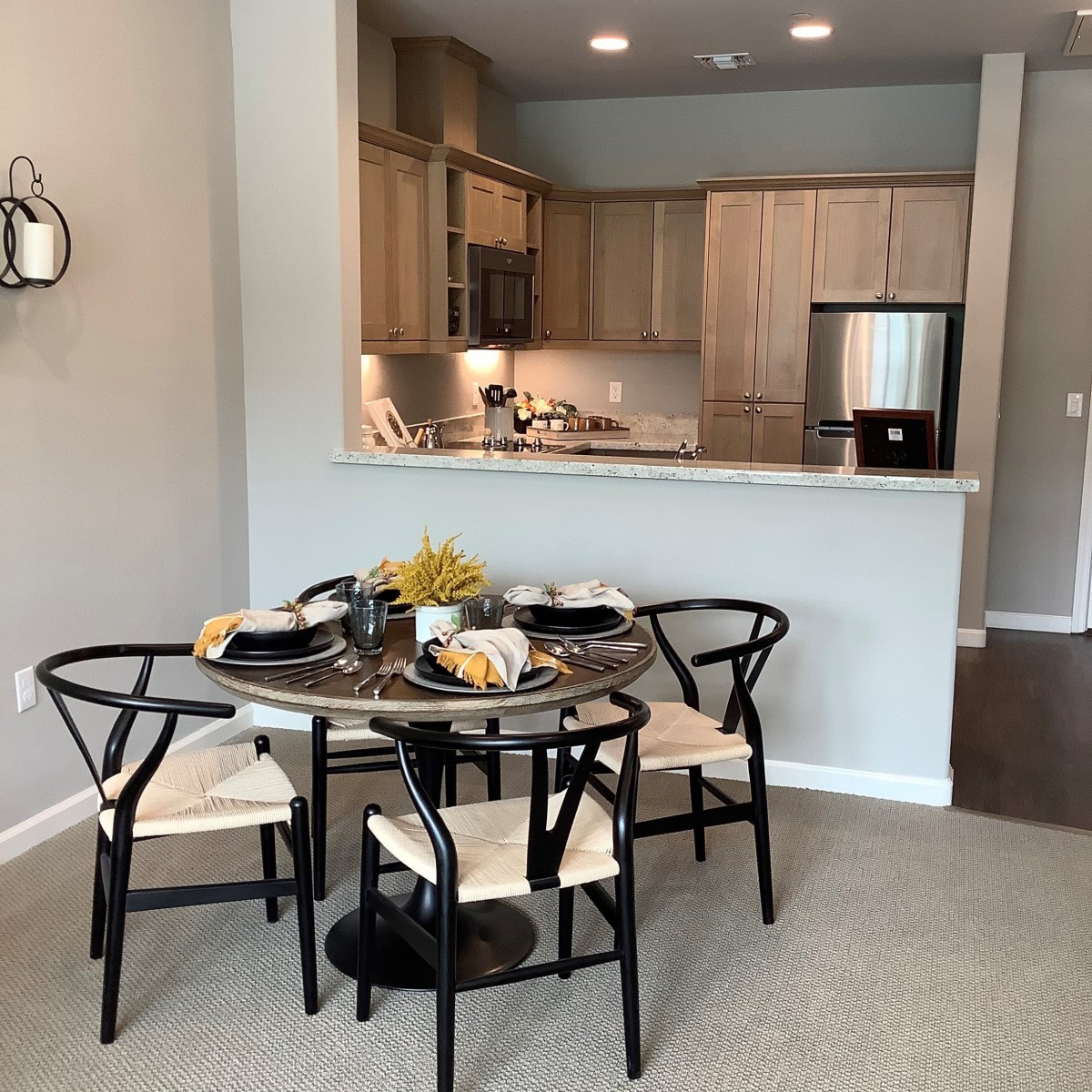 A modern open-plan kitchen and dining area with a round table set for four.