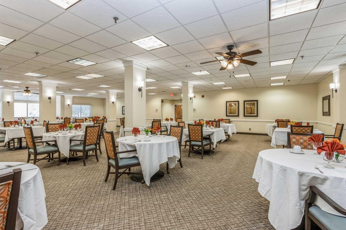 A spacious dining room with neatly arranged tables and chairs, featuring elegant decor.