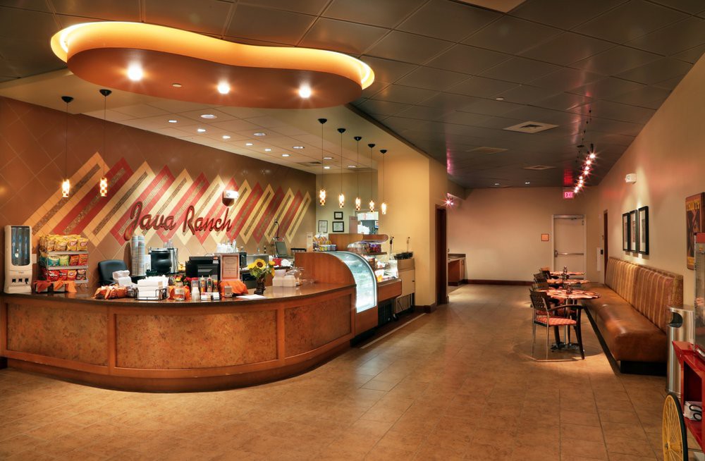 A modern cafe interior with a coffee counter and seating area.