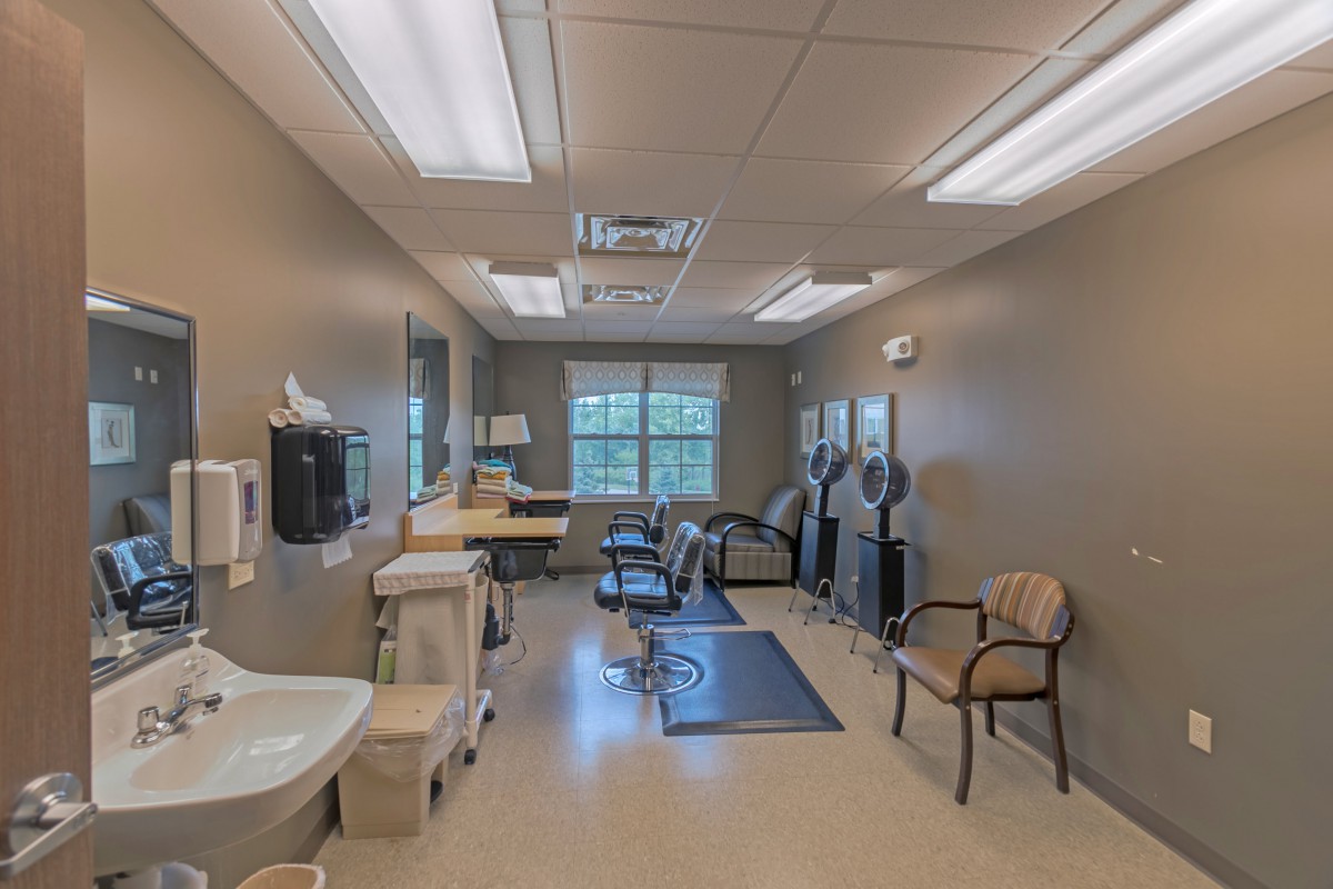 An empty physical therapy room equipped with exercise machines and seating for rehabilitation purposes.