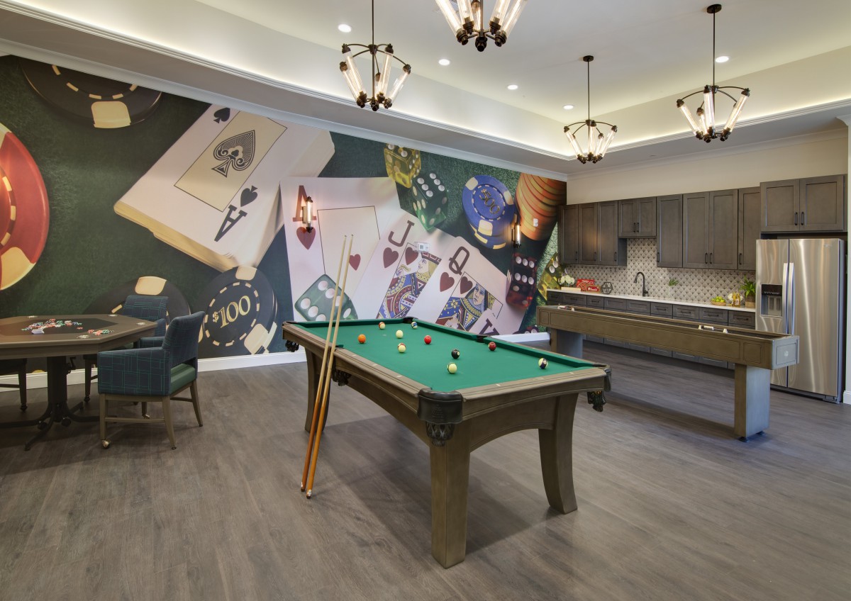 A modern game room featuring a pool table and an artistic wall mural.
