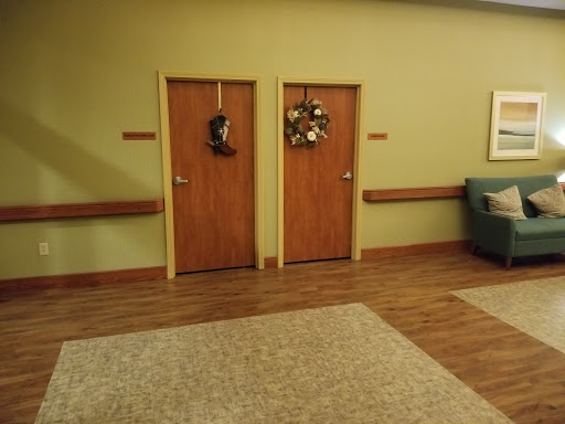 A cozy waiting area featuring two wooden doors adorned with seasonal wreaths.