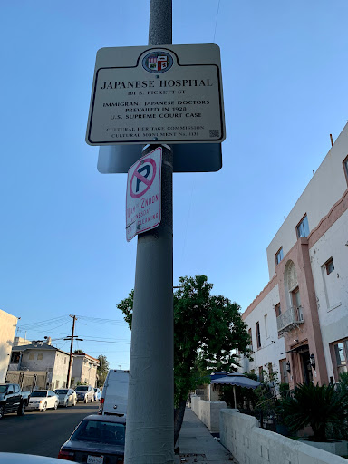 A street sign indicating parking regulations in an urban area.