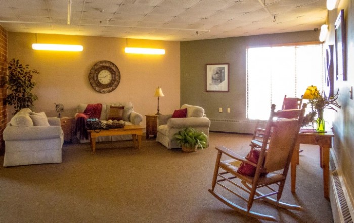A cozy living room featuring comfortable seating and a rocking chair.
