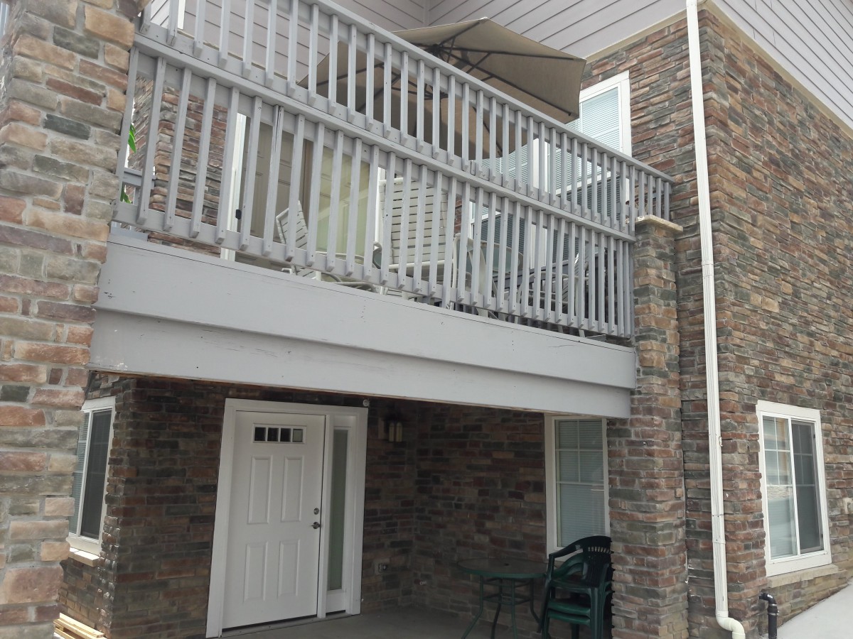 Two-story house with a brick exterior and a balcony above the porch.
